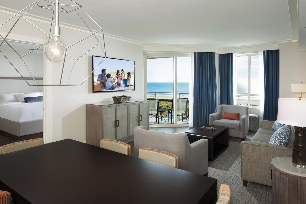 Ein Hotelzimmer mit Balkon, Essbereich und Wohnbereich.