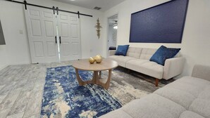 A living room with a sofa, a coffee table, and a blue patterned rug. - CasaDelaney DT Sodo district. Renovated Sleeps 16 (Orlando)