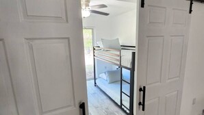 A room with a sliding door leading to a balcony with a bed and a ceiling fan. - CasaDelaney DT Sodo district. Renovated Sleeps 16 (Orlando)
