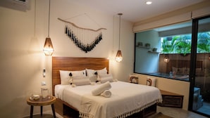 Un dormitorio moderno con cabecera de madera, una cama grande con ropa de cama blanca, dos mesitas de noche e iluminación colgante.