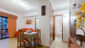 A dining area with a round table, chairs, and a view of the outdoors. - Next to Lisbon 100m from Beaches & Surf (Costa da Caparica)