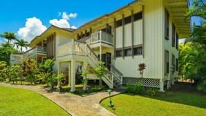 A two-story building with a balcony and a staircase. - Tropical Getaway North Shore Princeville Studio (Princeville)