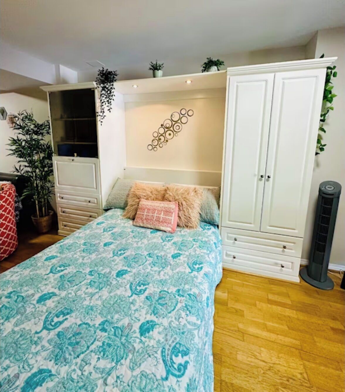 Un dormitorio con cama, armario, calefacción y un adorno en la pared.