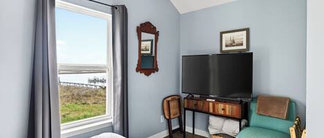 Une chambre avec un lit, une télévision, une chaise et une vue sur l’extérieur.