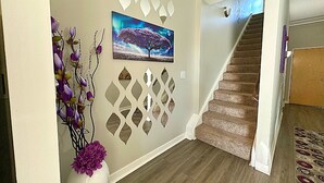 A staircase with a wooden handrail and carpeted steps leading to a landing.