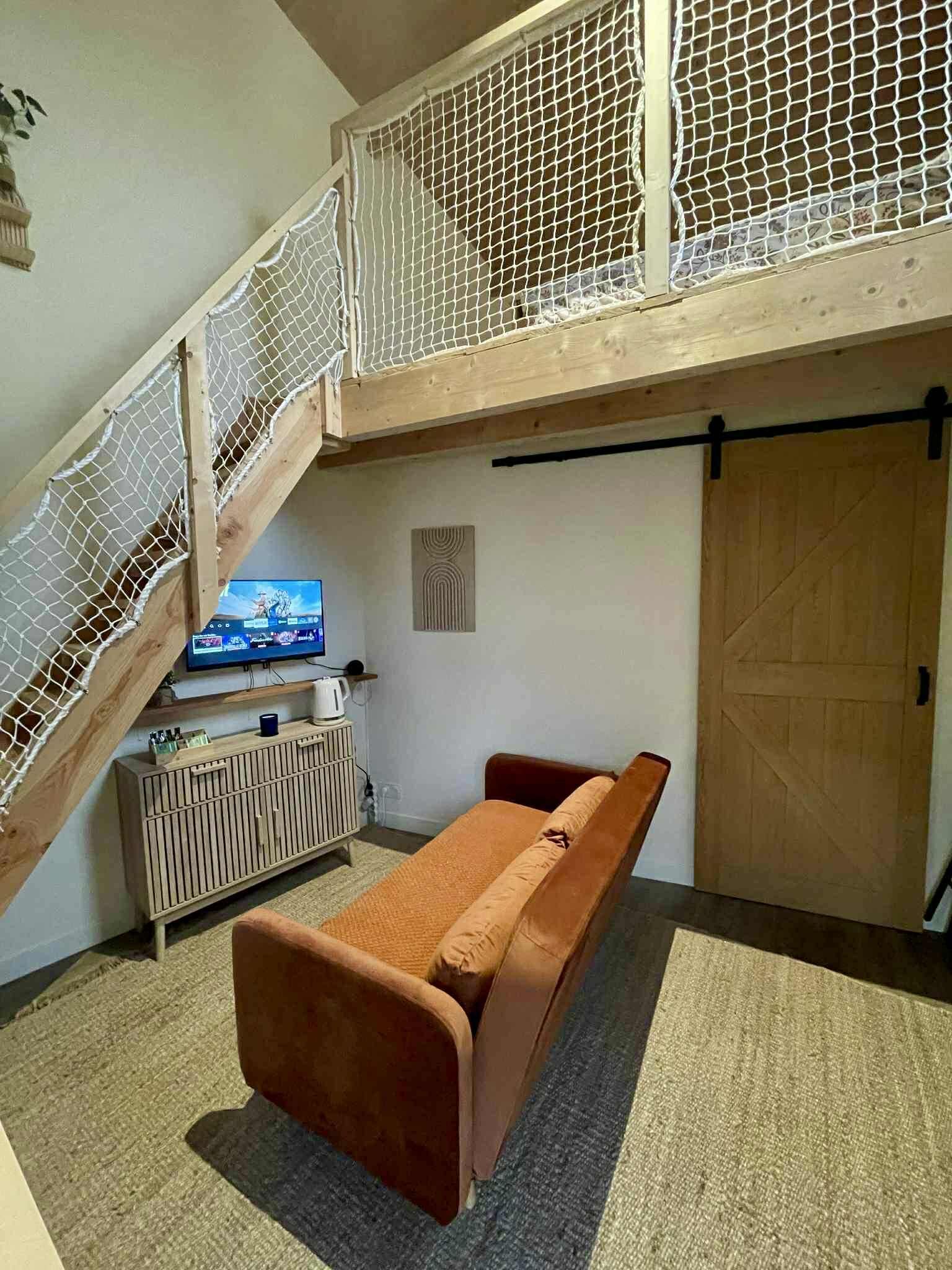Quarto com cama beliche, televisão, armário de madeira e porta.