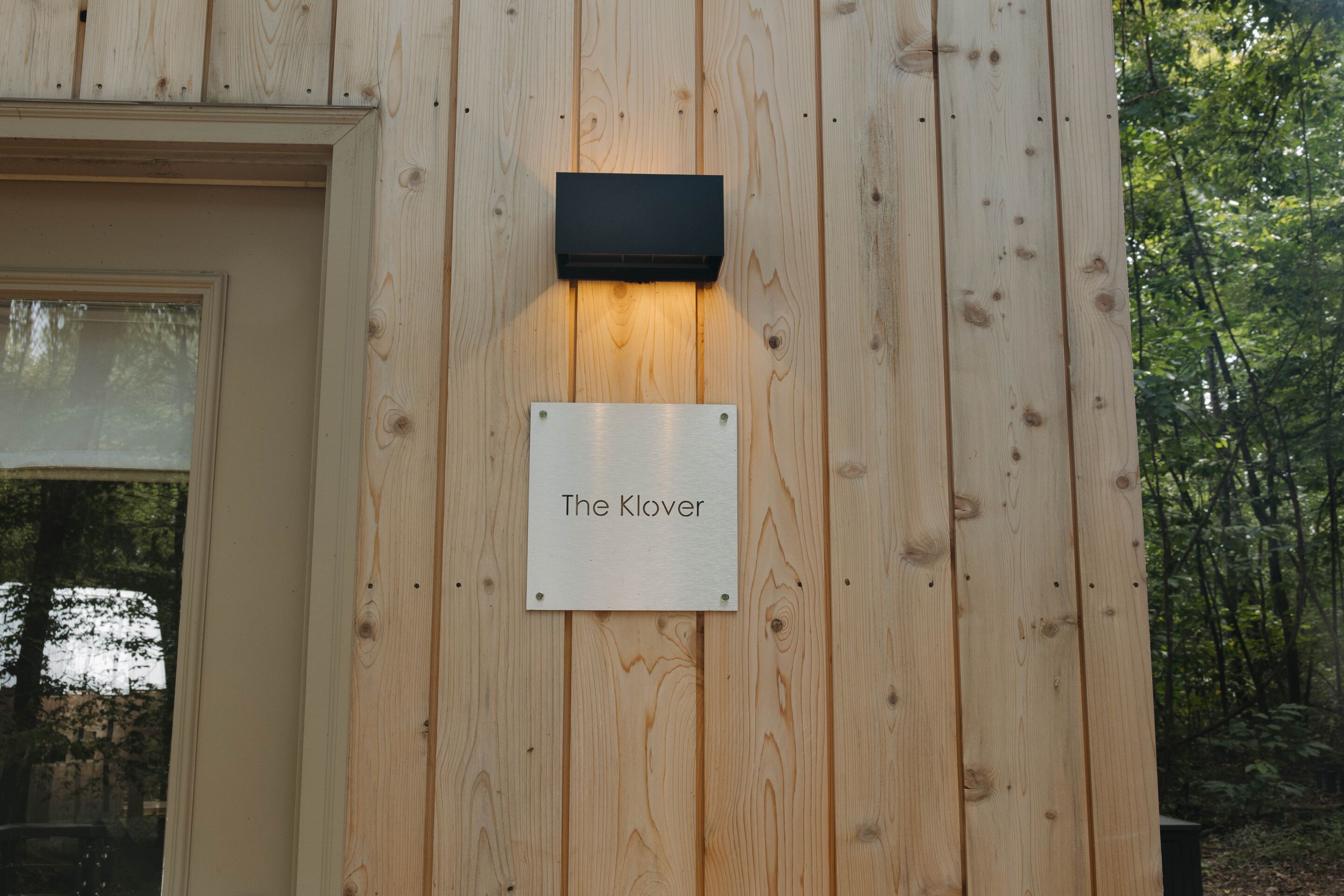 Pared de madera con un letrero que dice 'The Klover'.