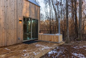 A wooden cabin with a glass door, a deck, and a sauna area. - Highland Cows/Wood-Fired Hot Tub/Forest Escape (Logan)