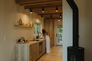 Une cuisine moderne avec des meubles en bois, un four encastré et une grande fenêtre.