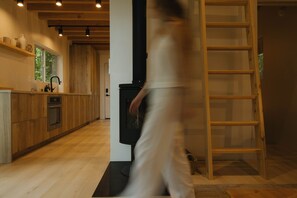 Une cuisine moderne avec des meubles de rangement en bois, un four encastré et une cuisinière noire.