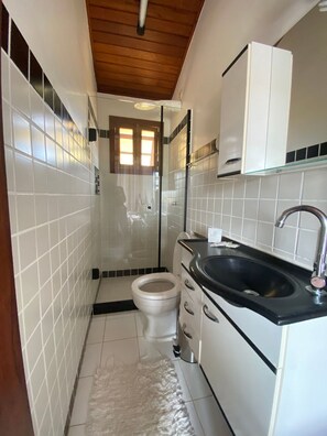 A compact bathroom with a toilet, sink, and shower. - CASA DE PRAIA EM GERIBÁ (Búzios)