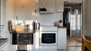 Una cucina compatta con fornello, forno e un piccolo ripiano.