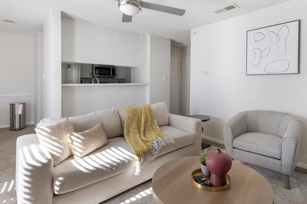 A modern living room with a sofa, armchair, and coffee table.