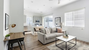 Un appartement moderne comprenant une cuisine, un coin repas et un salon.