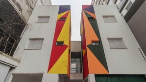 Un bâtiment composé de deux sections verticales, chacune présentant un motif géométrique aux couleurs rouge, jaune et verte.