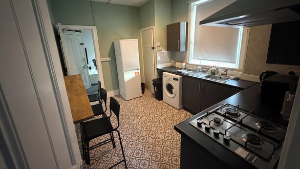 A compact kitchen with a gas stove, washing machine, and a refrigerator. - 3 bedroom flat close to city centre Newcastle upon Tyne (Newcastle upon Tyne)