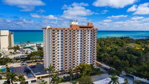 A high-rise hotel with multiple balconies, a parking lot, and a view of the ocean. - Terrific hotel suites in Fort Lauderdale with fitness room and AC (Fort Lauderdale)