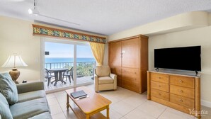 A living room with a sofa, a coffee table, a TV, a cabinet, a chair, and a balcony with a table and chairs. - Terrific hotel suites in Fort Lauderdale with fitness room and AC (Fort Lauderdale)