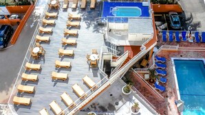 A deck with sun loungers, a pool, and a lifeguard stand. - Terrific hotel suites in Fort Lauderdale with fitness room and AC (Fort Lauderdale)