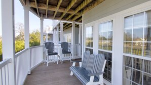 A covered porch with wooden beams, white railings, and two Adirondack chairs. - Steps to the pool 10 min to Bethany Beach, Water Views Kayaks & Free Activities Inc Golf @ Bear Trap (Millville)