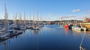 A marina with numerous boats docked, calm water, and a clear sky. - Le Balcon de la Baie (PAIMPOL)