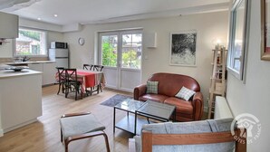 Un vaste espace de vie comprenant une table à manger, un canapé en cuir et une table basse en verre.