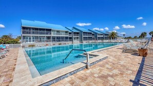 Una grande piscina all'aperto con un edificio moderno sullo sfondo.