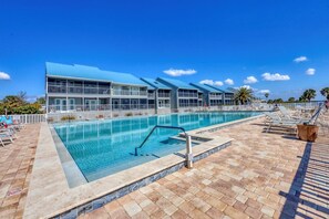 A large outdoor swimming pool with a modern building in the background. - Port Charlotte Private Waterfront Condo - Charlotte Harbor Water Views (Port Charlotte)