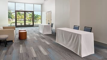 A conference room with two tables, chairs, and a sofa.