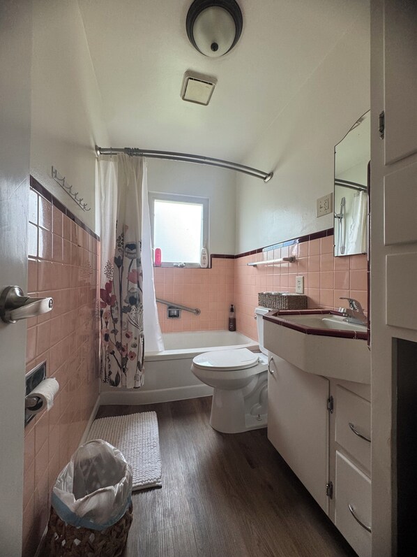 A compact bathroom with a toilet, sink, and bathtub. - California 50's (Lodi)