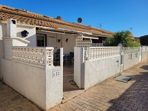 A traditional building with a tiled roof, a white exterior, and a number '132' on the wall. - Corner villa located in a secured residence with pool, Airco in the living room, for 5 people, at... (PORTIRAGNES)