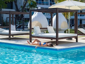 A pool area with lounge chairs and a canopy.
