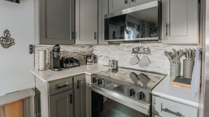 A modern kitchen with stainless steel appliances, a microwave, and a coffee machine. - Fishersville Oasis (Fishersville)