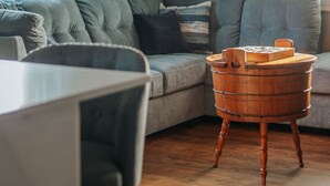 A cozy living room with a grey sofa, a wooden side table, and a wall with the word "HOME" spelled out in letters. - Fishersville Oasis (Fishersville)