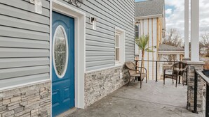 A house with a blue door, stone wall, and a patio with chairs. - Fishersville Oasis (Fishersville)