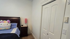A bedroom with a bed, a nightstand, and a white door.