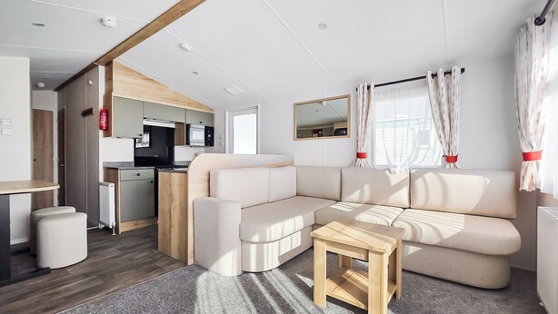 A modern RV interior with a living area, kitchenette, and a dining table. - Brand New Luxury Silver Caravan (Ingoldmells, Skegness)