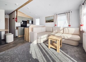 Ein modernes Wohnmobil-Interieur mit Wohnbereich, Küchenzeile und Esstisch.