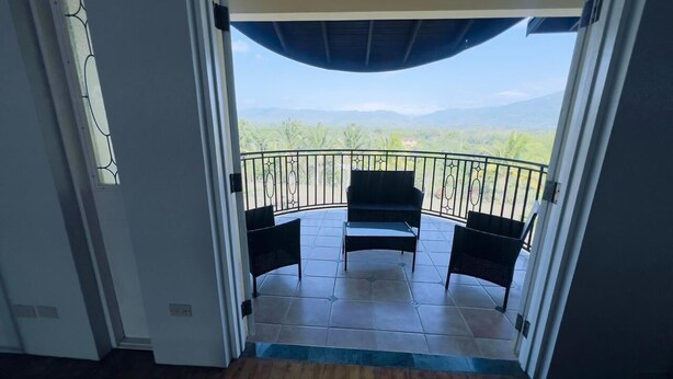 An open doorway leading to a balcony with a view of distant mountains and a clear sky. - Fabulous 4-bedroom house with AC in charming Bog Walk (Bog Walk)