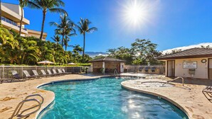 A clear blue pool with lounge chairs and palm trees in the background. - Lovely 2bd in Kihei, paradise awaits! (Kihei)