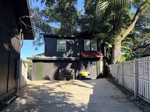 Ein zweistöckiges Haus mit Garage, Auffahrt und Holzzaun.