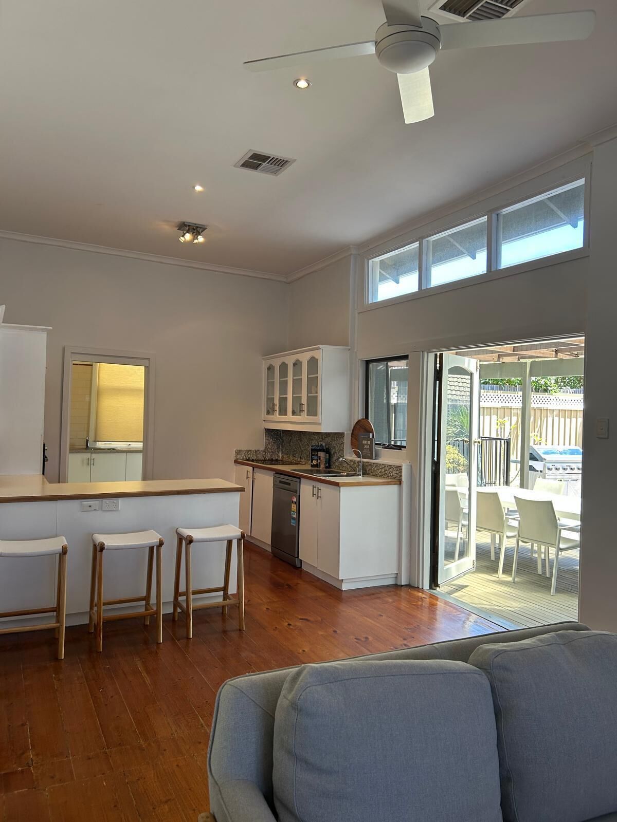 A spacious kitchen with a central island, a dining area with chairs, and a sliding glass door leading to an outdoor patio.