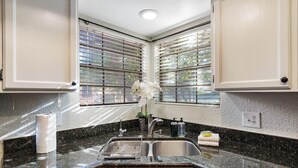 A kitchen with a granite countertop, stainless steel sink, and white cabinets. - Villa Antigua with Resort-Style Pool, Spa, Tennis in Scottsdale Old Town (Scottsdale)