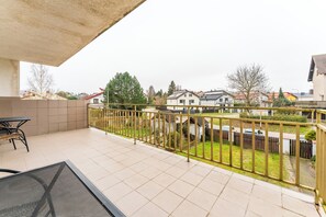 A balcony with a view of a residential neighborhood, a metal railing, and a table with chairs. - Kołobrzeg Brylantowa Sea Studio #5 (Kołobrzeg)