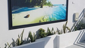 Eine große Außenleinwand zeigt eine tropische Strandlandschaft.