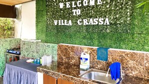 A reception area with a welcome sign, a counter, a sink, and a table with items on it. - Possibly the best private pool in Pampanga - all yours, no sharing (Magalang)