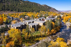 Aerial view of a residential complex along a river bordered by fall foliage. - SunRiver Condo Close to BC & Vail - Pet Friendly (Avon)