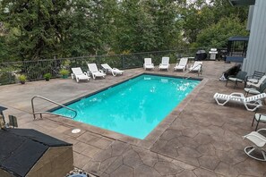 A rectangular swimming pool with a tiled deck, surrounded by white lounge chairs and potted plants. - SunRiver Condo Close to BC & Vail - Pet Friendly (Avon)