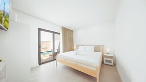 Ein modernes Hotelzimmer mit einem großen Bett, einem kleinen Nachttisch, Blick auf einen Swimmingpool und einer Glastür zum Außenbereich.