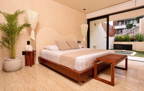 A modern bedroom with a wooden bed, a large potted plant, and a view of the outdoor area. - Loch Collection Tulum (Tulum)
